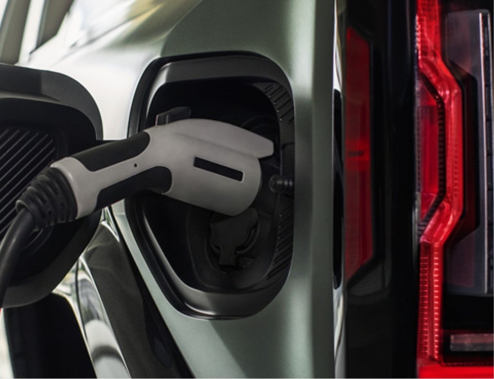 Close up of charging port with charger plugged in on a GMC Hummer EV SUV - Hansons GMC in Grafton ND